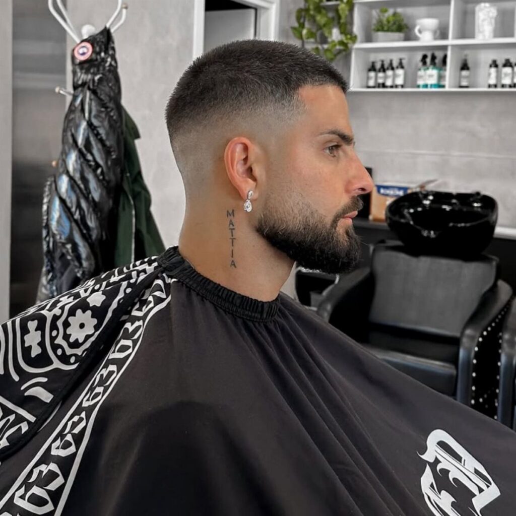 Man with a buzz cut fade and groomed beard in a barber shop