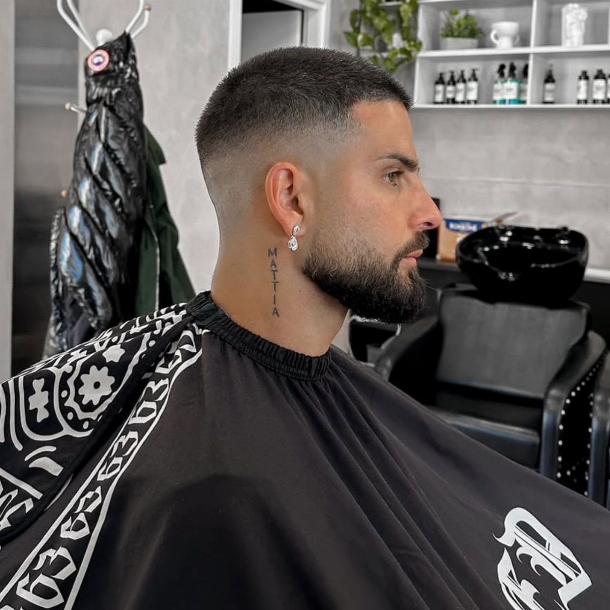 Man with a buzz cut fade and groomed beard in a barber shop