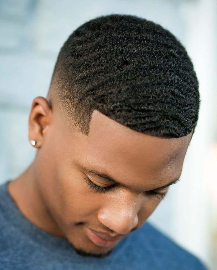 Black man with short hair featuring deep waves and a skin fade