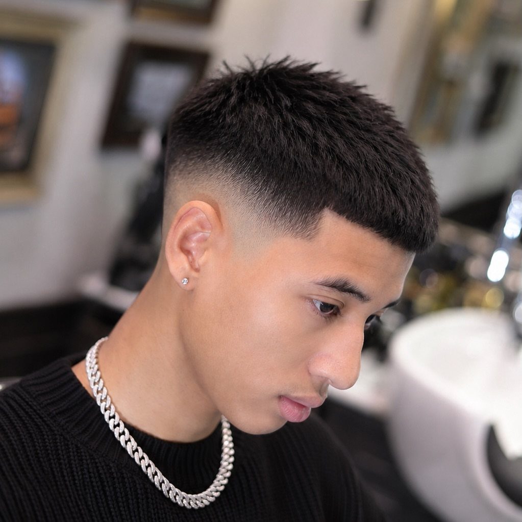 Young man with a textured crop haircut and high skin fade in a barbershop.
